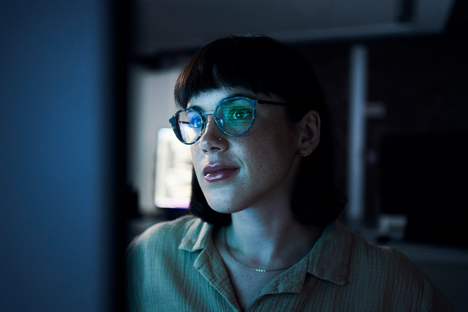 Woman engaged in work with the computer screen lighting her face.