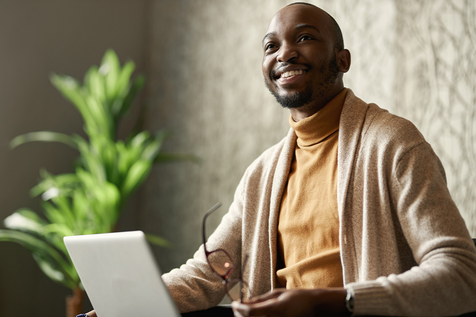 MBA student smiling while reviewing coursework on a laptop.