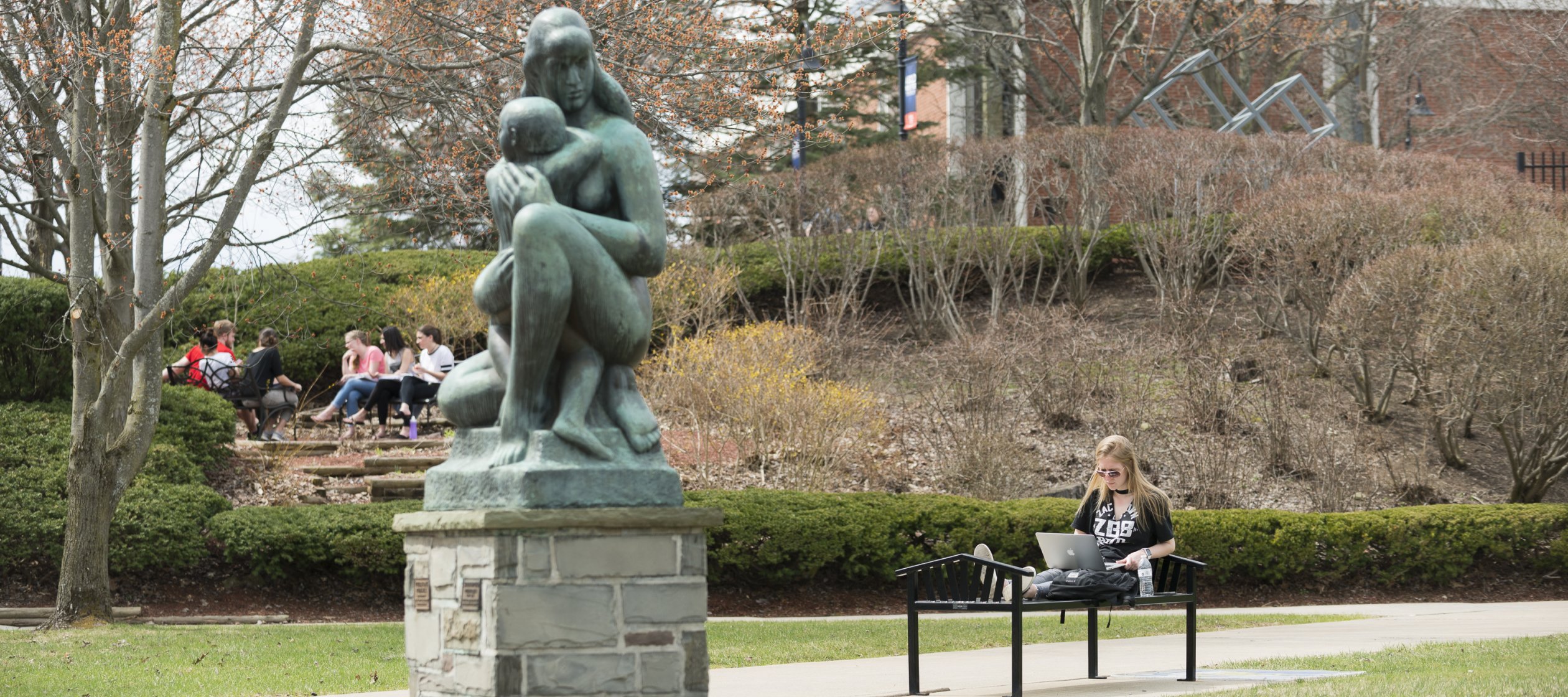 Campus Scenic Spring - Students work near statue